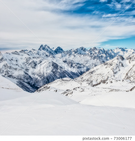 Snowy blue mountains in clouds 73006177