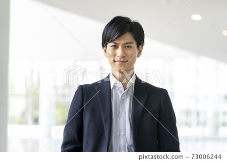 一個商人在他30年代初看著相機的肖像 73006244