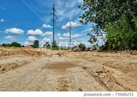 Road to the construction site. Rural road with blue sky background 73006255