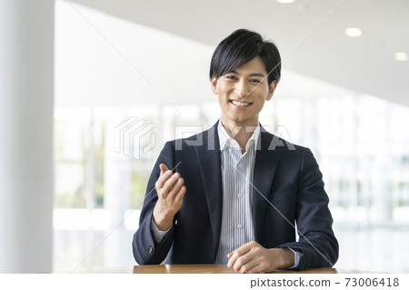 A businessman in his thirties talking looking at the camera 73006418