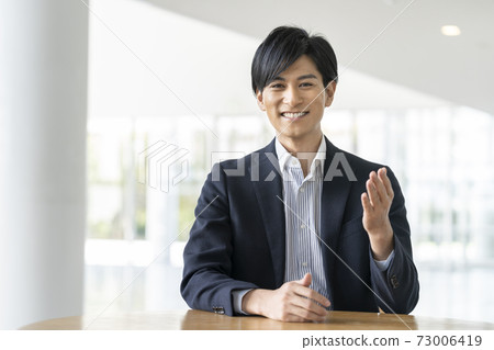 A young man talking because he is looking at the camera 73006419