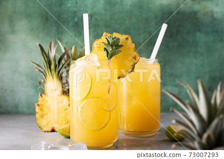 freshly squeezed pineapple juice with lime wedges and ice freshly squeezed pineapple juice with lime wedges and ice 73007293