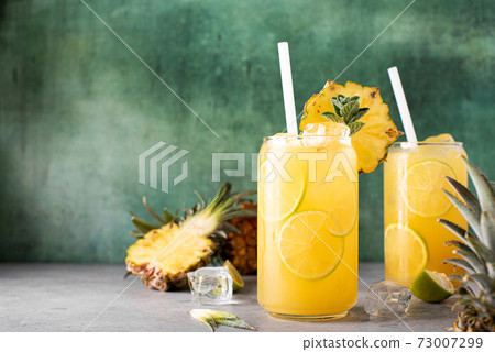 freshly squeezed pineapple juice with lime wedges and ice freshly squeezed pineapple juice with lime wedges and ice 73007299