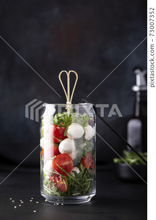 mozzarella with cherry tomatoes and arugula in a glass jar mozzarella with cherry tomatoes and arugula in a glass jar 73007352