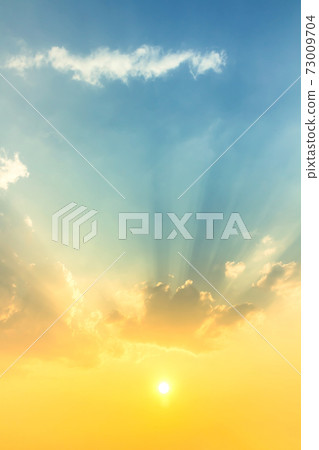sky and clouds nature background, bright sunset with orange sun light in blue sky with soft clouds and sun rays sky and clouds nature background, bright sunset with orange sun light in blue sky with soft clouds and sun rays 73009704