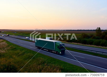 Truck with driving along highway. Out of focus, possible granularity, motion blur 73009759