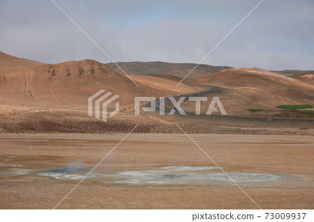 Namaskard. Fumarole field in Namafjall, Iceland. Namaskard geothermal beauty landscape with mud pools and steam. Icelandic brown landscape. Landscape which pools of boiling mud and hot springs 73009937