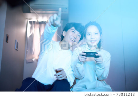 年輕的男人和女人在房間裡玩電子遊戲 73011218