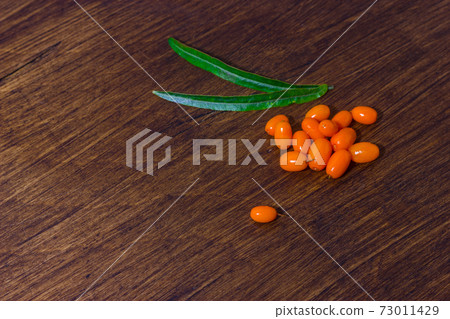 Sea buckthorn berries and leaves on wooden background. Copy space. Sea buckthorn berries and leaves on wooden background. Copy space. 73011429