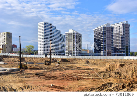 Construction site with machinery for deep foundation piling. Vibrating hydraulic hammer. Construction site with machinery for deep foundation piling. Vibrating hydraulic hammer. 73011869