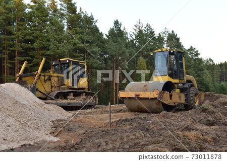 Dozer and Vibro Roller Soil Compactor at road construction and bridge projects in forest area. Dozer and Vibro Roller Soil Compactor at road construction and bridge projects in forest area. 73011878
