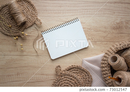 Creative composition with natural jute twine roll - linen or cannabis and body jute washclothes or for dishes on wooden background with copyspace. Handmade DIY and hobby concept, selective focus 73012547