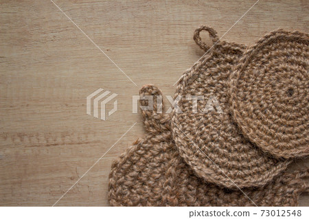 Natural body jute washclothes or for dishes, and twine roll - linen or cannabis, on light grey background with copyspace for text. Handmade DIY and hobby concept, selective focus 73012548
