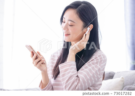 聽到在智能手機的音樂的一個少婦 73017282