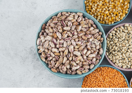 Bunch of various uncooked beans, corns and red lentils on marble surface 73018193