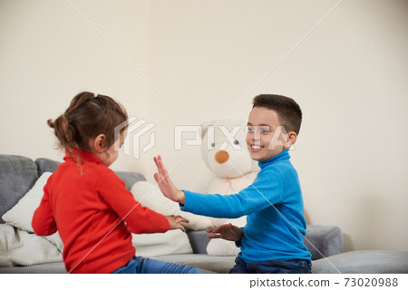 Happy boy and girl claping their hands while playing together. Happy boy and girl claping their hands while playing together. 73020988