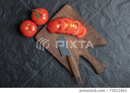A group of tomatoes, sliced or whole on black background A group of tomatoes, sliced or whole on black background 73021861