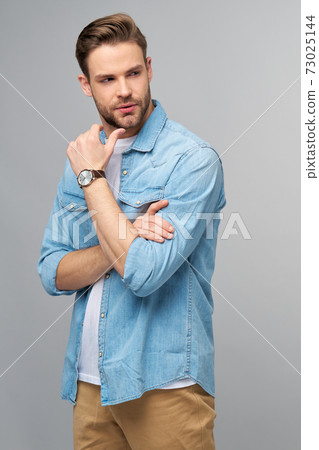 Portrait of young handsome caucasian man in jeans shirt over light background 73025144