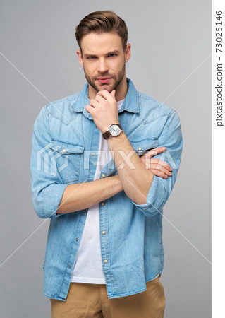 Portrait of young handsome caucasian man in jeans shirt over light background Portrait of young handsome caucasian man in jeans shirt over light background 73025146
