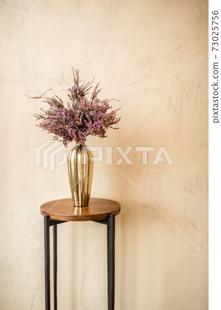 Dried Calluna flower in a gold vase 73025756