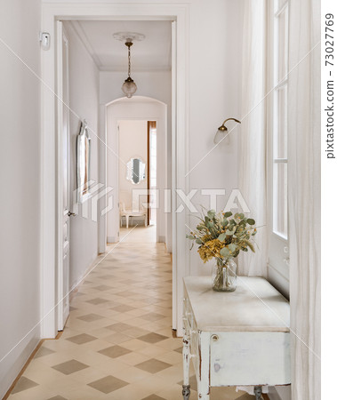 Hallway decorated in vintage style overlooking a long corridor Hallway decorated in vintage style overlooking a long corridor 73027769