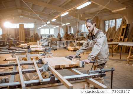 Carpenter working at the carpentry manufacturing Carpenter working at the carpentry manufacturing 73028147