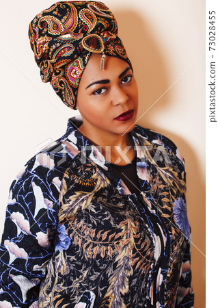 beauty bright african woman with creative make up, shawl on head like cubian closeup smiling 73028455