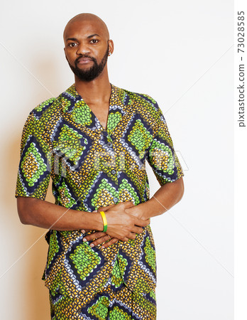 portrait of young handsome african man wearing bright green national costume smiling gesturing, entertainment stuff portrait of young handsome african man wearing bright green national costume smiling gesturing, entertainment stuff 73028585