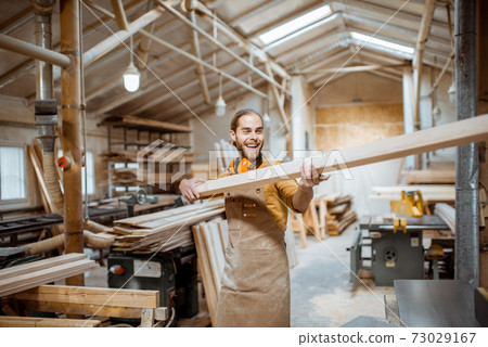Carpenter working with wood indoors 73029167