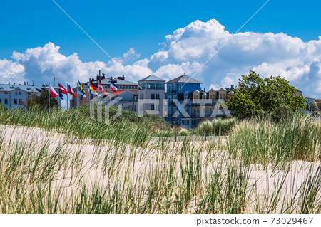 View to buildings with dune in Warnemuende, Germany View to buildings with dune in Warnemuende, Germany 73029467