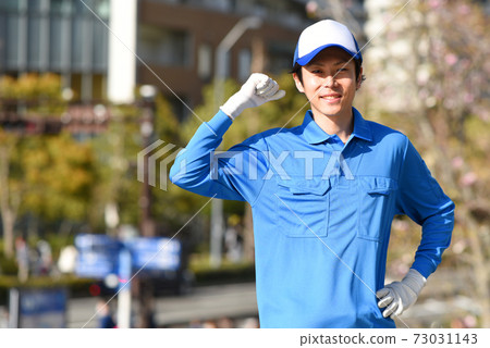 A man in work clothes taking a guts pose 73031143