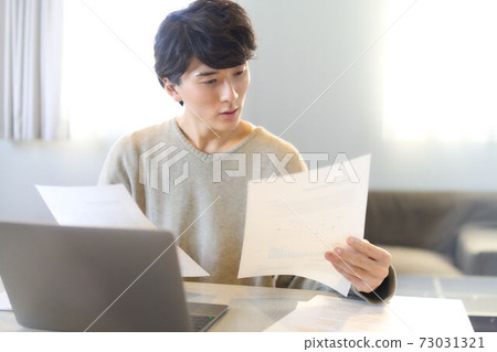 Young man working on a PC at home Young man working on a PC at home 73031321