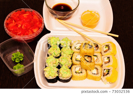 A set of ready-made sushi and rolls and ingredients for them. 73032536