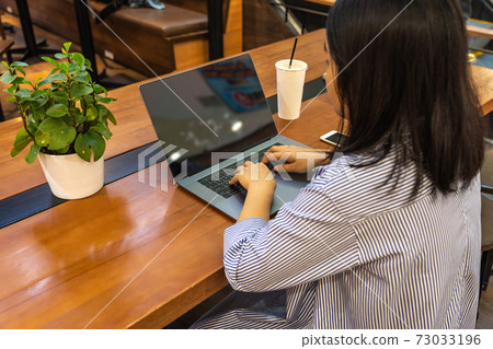 Modern woman using computer laptop on table 73033196