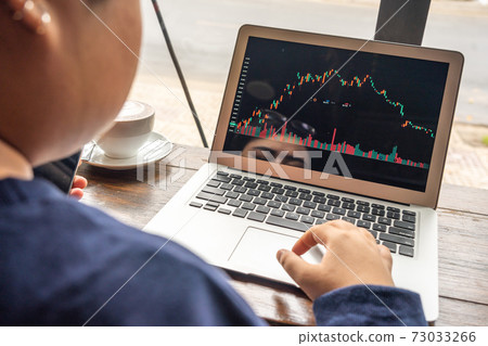 Asian businesswoman looking at stock market trading graph on computer Asian businesswoman looking at stock market trading graph on computer 73033266