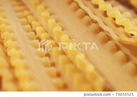 Uncooked pasta mafaldine Uncooked pasta mafaldine 73033525