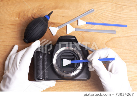 Professional cleaning of camera with swab and air dust blower Professional cleaning of camera with swab and air dust blower 73034267