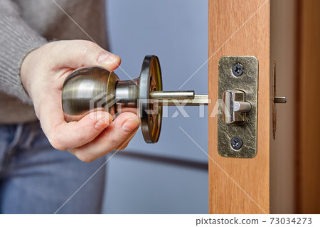 An Carpenter shoves the door handle spindle through the face bore and the latch assembly. 73034273