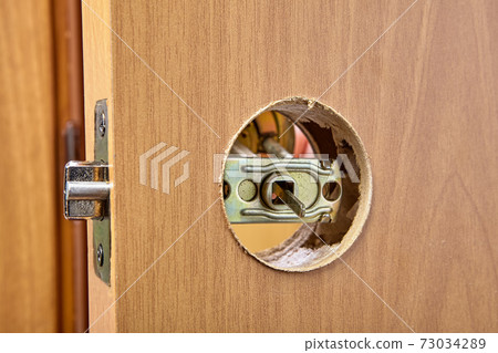 The installer pushes the spindle of door handle through the hole in the latch assembly and face bore. The installer pushes the spindle of door handle through the hole in the latch assembly and face bore. 73034289