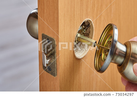 Installing a new brass handle in face bore of interior door. The spindle connects the doorknob parts. 73034297