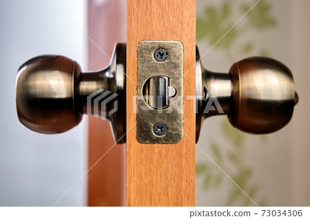 Close-up of new brass door handles with latch. 73034306