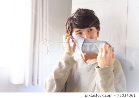 A young man wearing a mask 73034361