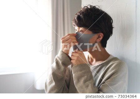 A young man wearing a mask 73034364