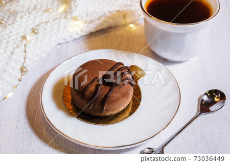 Contemporary chocolate mini mousse cakes with cream insert, covered with chocolate velvet spray and chocolate gourmet glaze, decorated with whipped chocolate ganache 73036449