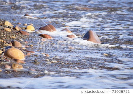 Set of rocks on the shore of the beach Set of rocks on the shore of the beach 73036731