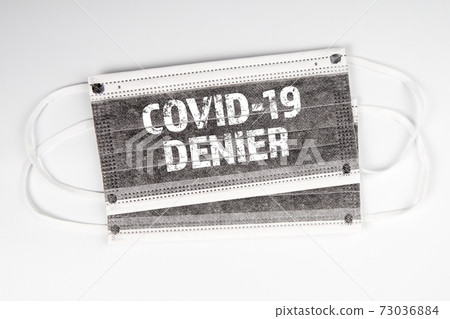 COVID-19 Denier. Two face masks on a white background COVID-19 Denier. Two face masks on a white background 73036884