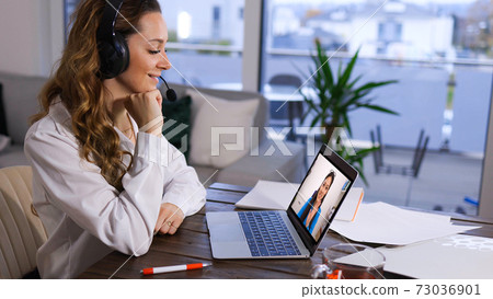 Young woman at home does a video chat with her friend Young woman at home does a video chat with her friend 73036901