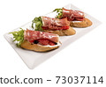 Bruschettes with jamon and grapefruit. Isolated image on white background. 73037114
