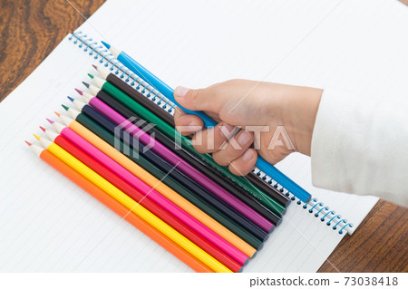 Toddler with colored pencils 73038418