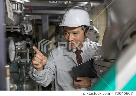 一名商人在工廠設施進行設備維護 一名商人在工廠設施進行設備維護 73040667